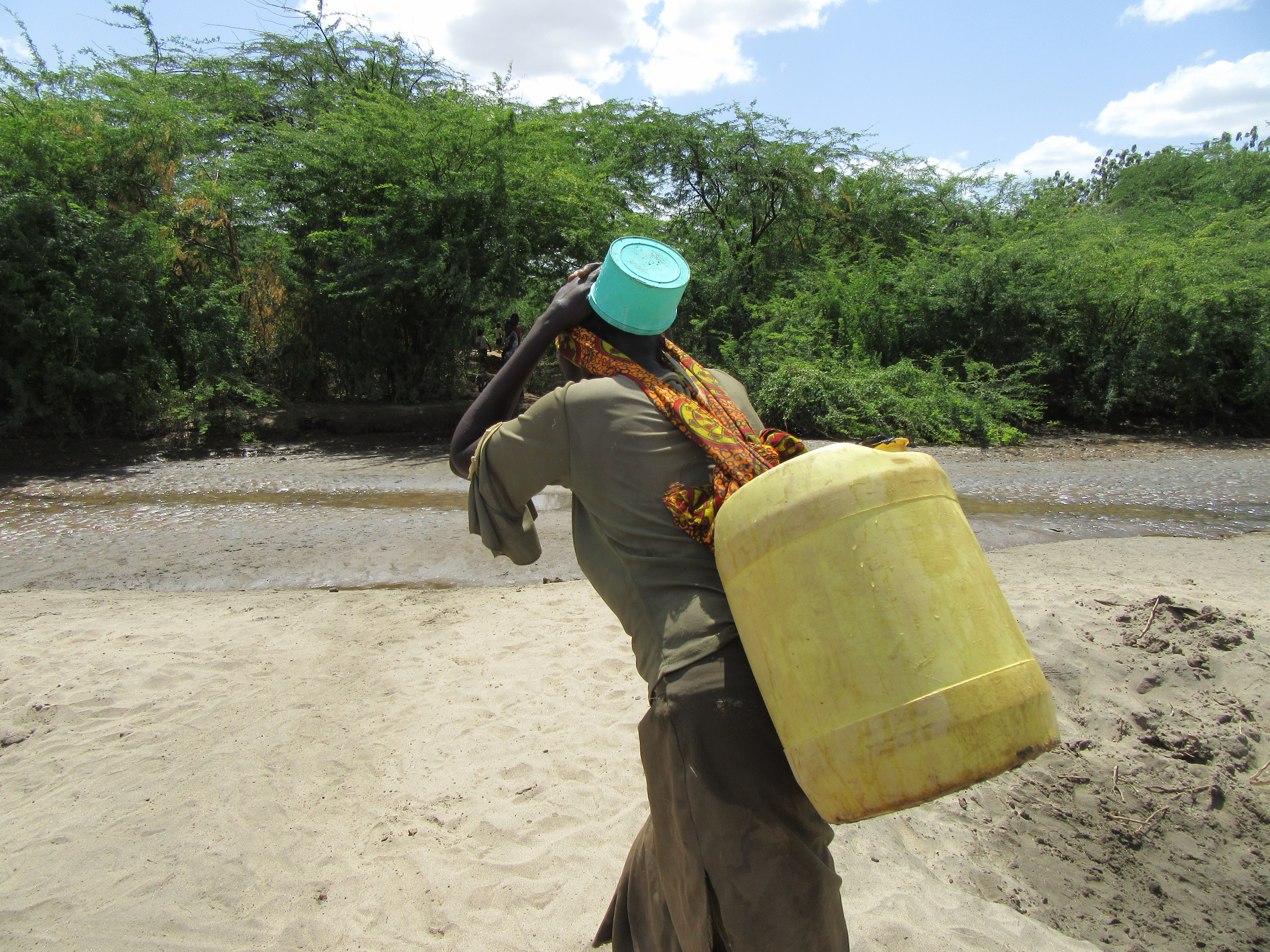 Woman carrying a jerrycan of water in Turkana; Credit: Rob Hope/REACH