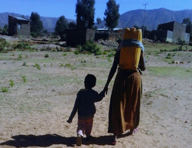 A woman and her son, on the way home after fetching water from a distant communal water point